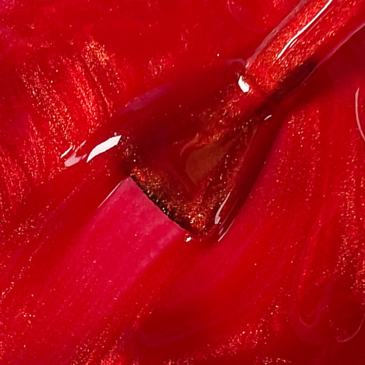 Dettaglio macro della texture lucida e brillante dello smalto rosso Chili Pepper con pennello applicatore.