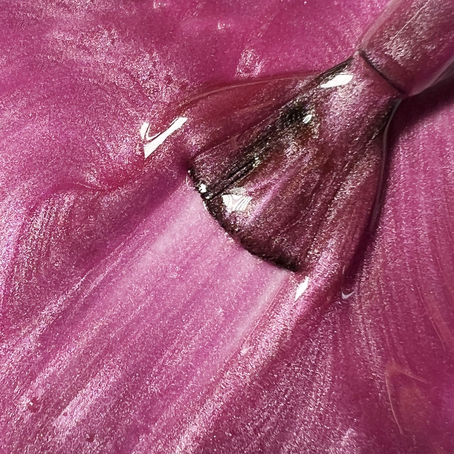 Primo piano texture smalto peel-off fucsia scintillante Baby Pink con pennello, finish glitterato lucido