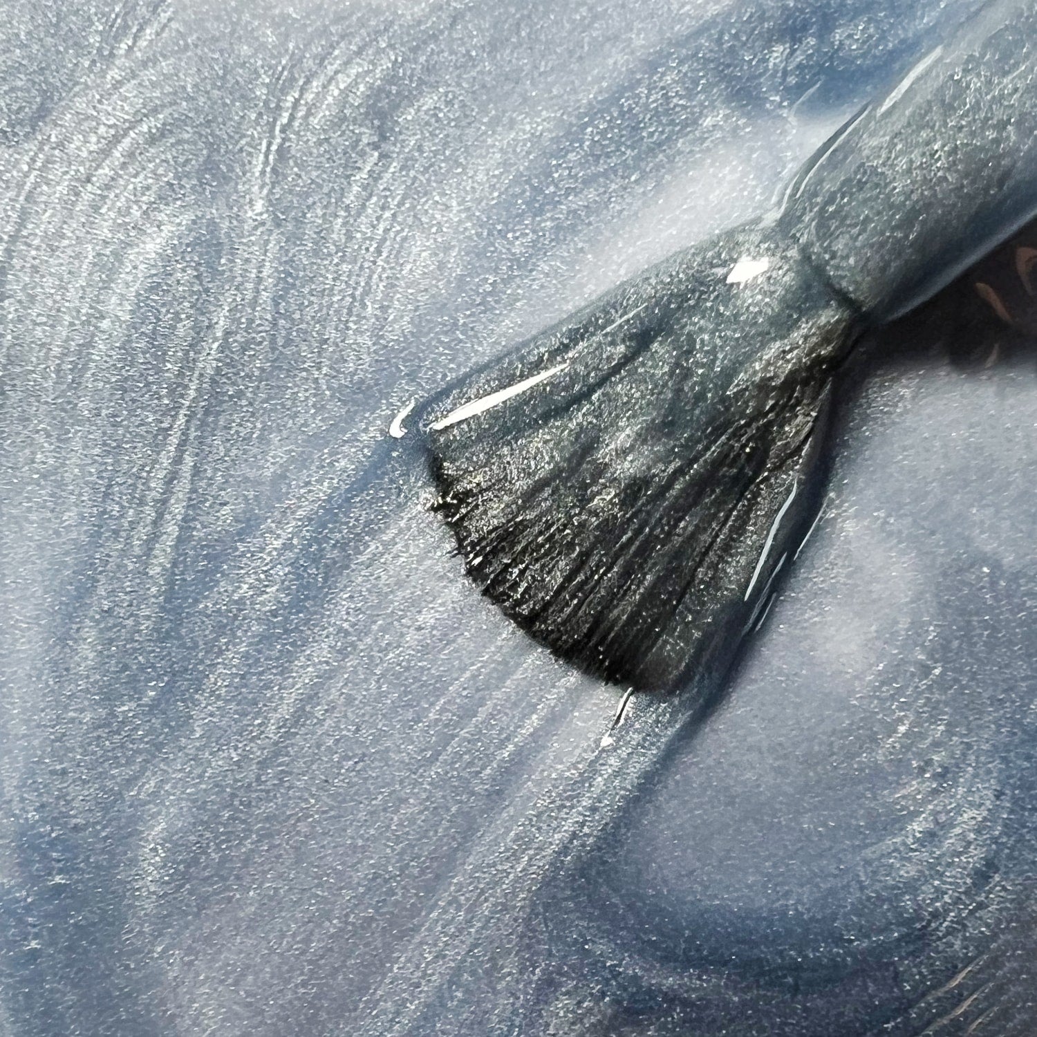 Primo piano texture smalto peel-off blu grigio Light Blue con pennello, finish glitterato metallico