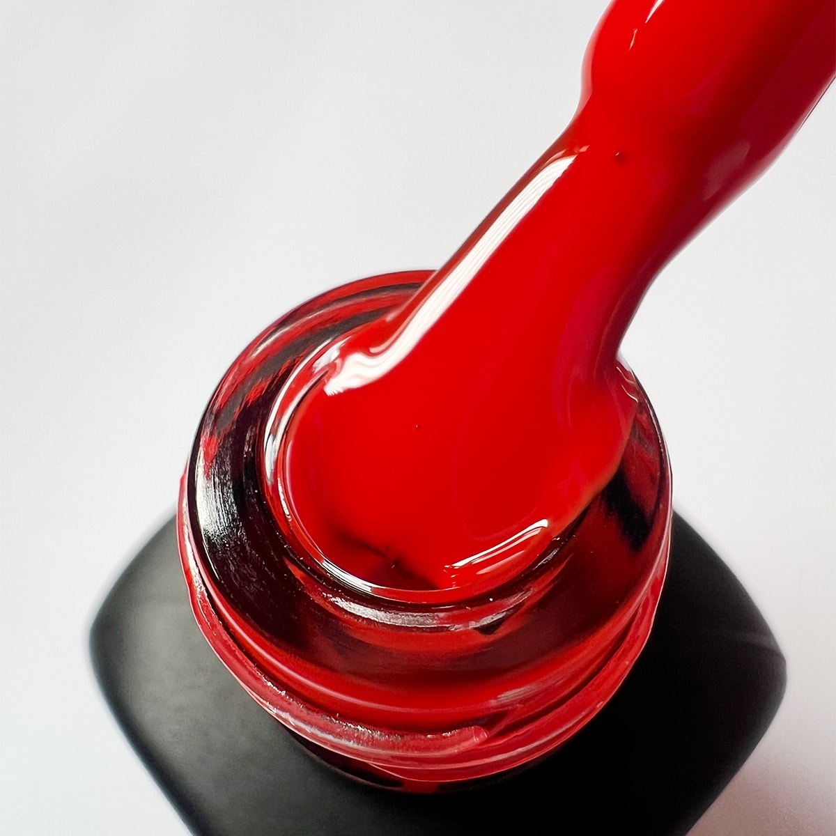 Pennello intinto nello smalto peel-off rosso vivo Passion Fruit, texture cremosa e coprente