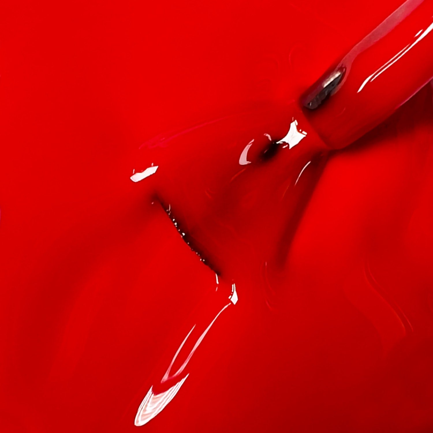 Primo piano texture smalto peel-off rosso brillante Passion Fruit con pennello, finish lucido intenso