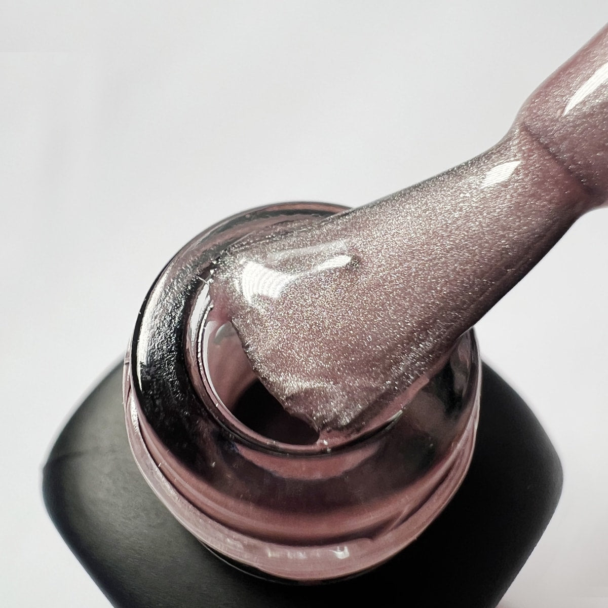 Pennello intinto nello smalto peel-off rosa mauve glitterato Soft Pink, texture cremosa con micro-brillantini argento